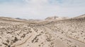 Path road in the middle of a mountains sand desert with blue bright sky in background. Concept of desertification or climate