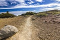 Path in semidesert with stones and blue sky