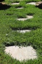 Path of stepping gray brown stepping stones in green grass, middle focus Royalty Free Stock Photo