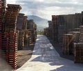 Path through storage area with pallets stacks and nature landscape