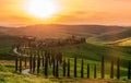 Path to hill house through cypress trees and sunrise view of stunning rural landscape of Tuscany, Italy