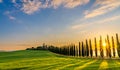 Path to hill house through cypress trees and sunrise view of stunning rural landscape of Tuscany, Italy