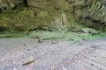 Path to huge rock formation with uneven texture and moss with cairns or apachitas at the bottom Royalty Free Stock Photo