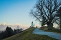 Path towards cute  fantastic charming Saint Primoz church on a small hill with mountains in background at sunset, Jamnik village, Royalty Free Stock Photo