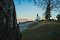 Path towards cute  fantastic charming Saint Primoz church on a small hill with mountains in background at sunset, Jamnik village, Royalty Free Stock Photo