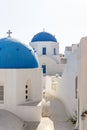 Path through two blue dome towers with crosses, Oia, Santorini, Greece Royalty Free Stock Photo