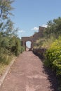 Dirt road inside the medieval castle of Lorca, Mazarron, Murcia, which leads to an arched stone entrance Royalty Free Stock Photo