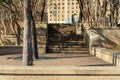 Path or walkway area trees and cement wall with urban building background and sunny shade for resting weary travelers Royalty Free Stock Photo