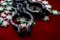 Pathological gambling and addiction to casino games concept with a pair of metal shackles and scattred chips on a red felt Royalty Free Stock Photo