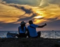 Pathos, Cyprus / May 19, 2016 - Young couple sits on beach and e Royalty Free Stock Photo