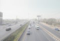 PATHUM THANI, THAILAND-MARCH 10, 2023: Cars driving on highway road with air pollution. Smog and fine dust of pm2.5 covered city.