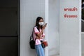 Adolescent girls wearing glasses with hygienic mask and stand using a mobile phone at the parking entrance
