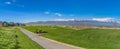 Pathway amid a rich green field leading to houses in the distance Royalty Free Stock Photo