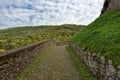 Pathway with cobblestone with green growth leading up the hill Royalty Free Stock Photo