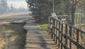 the pathway with handrail in the fog field to the mountains Royalty Free Stock Photo