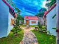 A pathway leading to a small house with a red roof. wooden cottage.