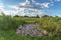 Pathway made of irregular rocks against grass covered land and distant houses