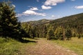 Pathway on mountain meadow with trees, hills on the background and blue sky with clouds in Beskids Royalty Free Stock Photo