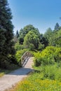 Pathway in a park to the wooden decorative bridge over a creek Royalty Free Stock Photo