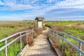 Pathway with railing and sign board with roof on grass land in Huntington Beach Royalty Free Stock Photo