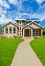 Pathway to Ideal residential house in perfect neighbourhood. Family house with big green lawn in front on blue sky background Royalty Free Stock Photo