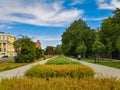 Pathways with colorful path with flowers and bushes between at sunny cloudy day