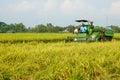 Pati, Indonesia - January, 2022 : Automatic rice harvester machine is being used to harvest the fields.