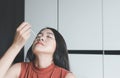 Patient asian woman doing a nasal swab self test rapid antigen testing kit for checking a covid-19 at home Royalty Free Stock Photo