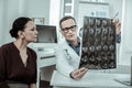 Demonstrative medical worker showing x-ray photo to patient