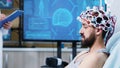 Patient with brainwaves scanning headset sitting on bed