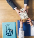 Patient bribing a greedy doctor Royalty Free Stock Photo