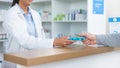 Patient buying medicine from pharmacist at the pharmacy store. Customer receives prescription medication at the chemist