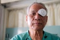 Patient covering eye with protective shield after eyes cataract surgery in hospital Royalty Free Stock Photo