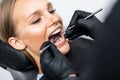 Patient at dentist office. Close-up of young woman sitting at the chair in dental office and doctor examining teeth Royalty Free Stock Photo