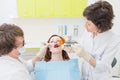 Patient at a dentist office with doctor and assistant, Caries treatment