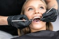 Patient at dentist office. Close-up of young woman sitting at the chair in dental office and doctor examining teeth Royalty Free Stock Photo