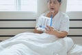 Patient elderly people woman using incentive spirometer or three balls for stimulate lung in bedroom Royalty Free Stock Photo