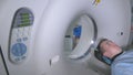 Patient in a Emergency hospital MRI scanner. Man lays in Magnetic Resonance Image device, making tomographic scanning.