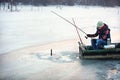 Patient fisherman pulls hooked fish from water Royalty Free Stock Photo