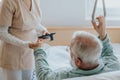 Patient gets up from the hospital bed by helping himself with a special handle