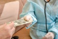 The patient gives the doctor money, a bribe for treatment. The concept of corrupt doctors Royalty Free Stock Photo