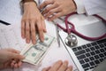 Patient giving money to medical doctor in hospital setting Royalty Free Stock Photo