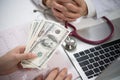 Patient giving money to medical doctor in hospital setting Royalty Free Stock Photo