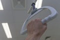 Patient hand holding hospital bed trapeze in intensive care unit , on background ceiling lights