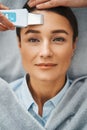 Patient having her pores unclogged with an ultrasonic skin scrubber