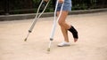 Patient with injured ankle walking on crutches outdoors, leg strain, fracture Royalty Free Stock Photo