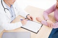 Patient listening intently to a male doctor explaining patient symptoms or asking a question as they discuss paperwork together