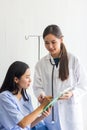 Patient listening intently to a male doctor explaining patient symptoms or asking a question as they discuss paperwork together