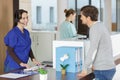 patient looking at female receptionist using headset phone at reception Royalty Free Stock Photo