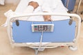 Patient lying in hospital bed with broken leg. Top view. Hospitalization and medical care concept.